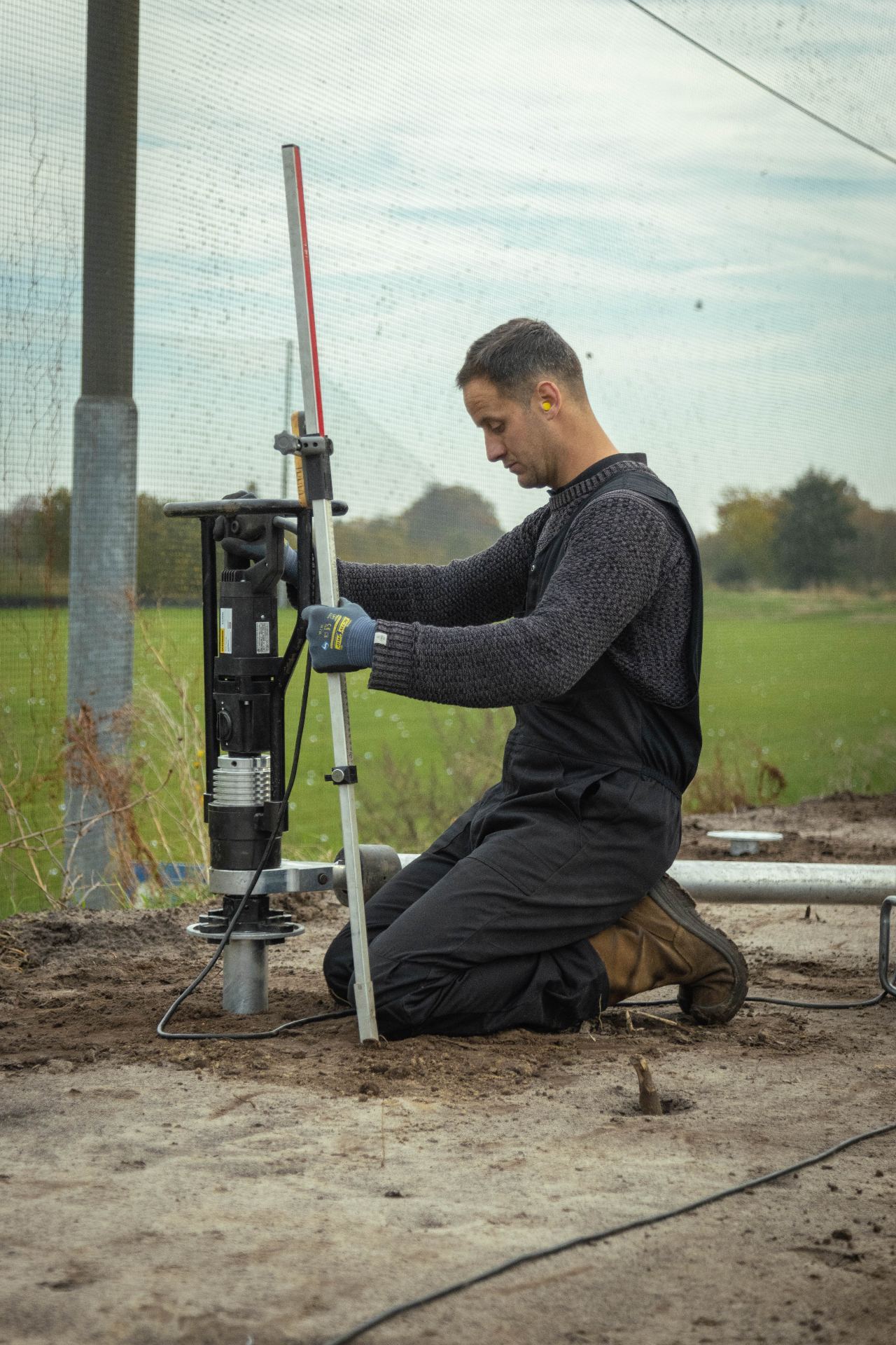 Vakman bij schroefpaalmachine
